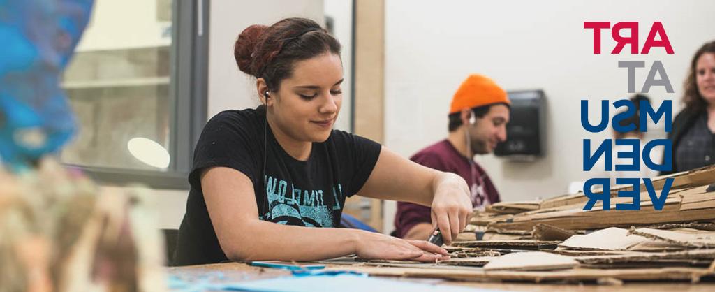 Student cutting cardboard